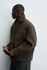 Chaquetón de corte regular fit, con cuello solapa, manga larga y cierre frontal con botones. Presenta dos bolsillos de plastrón con solapa en la parte frontal y un bolsillo interior.