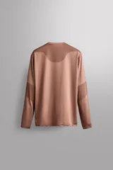 Camiseta de entrenamiento de manga larga Zara Athleticz de color marrón, corte regular fit y cuello redondo. Está confeccionada en tejido técnico elástico de secado rápido y cuenta con un bolsillo en el pecho con cierre de cremallera.