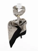 Pañuelo de seda con estampado geométrico en blanco, negro y gris, que incluye un anillo metálico dorado para sujetarlo.
