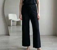 Pantalón de lanilla color negro, de corte recto y holgado, con cintura elástica y cordón ajustable.