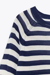 Jersey de punto liso, color azul brillante, con cuello redondo y manga larga. Presenta acabados en rib en puños, cuello y bajo, con aberturas laterales en el ruedo.