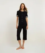 Conjunto de pijama femenino de dos piezas, compuesto por una blusa de manga corta con detalle de encaje en mangas y cuello, abotonada al frente, y un pantalón capri. Ambas prendas son de viscosa certificada.