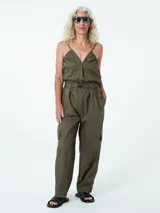 Mono largo color verde militar, con breteles finos, escote en V, cierre frontal con botones, cinturón con hebilla metálica, bolsillos laterales y corte holgado.