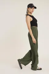 Pantalon cargo de corte recto y tiro alto, confeccionado en tela cupro color verde militar. Presenta bolsillos laterales tipo cargo con solapa y bolsillos frontales clásicos.