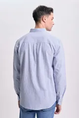 Camisa celeste con rayas verticales blancas, de lino, manga larga y corte clásico.