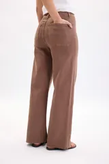 Pantalón jean ancho y elastizado en color marrón, de corte recto y tiro medio, con bolsillos y trabillas para cinto.