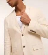 Saco de traje masculino confeccionado en mezcla de lino y viscosa, con cierre frontal de dos botones, bolsillos laterales con solapa y medio forro interior.