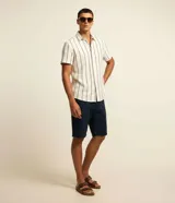 Bermuda masculina de sarga color blanco, con diseño recto, cierre con botón y cremallera, y bolsillos delanteros y traseros.