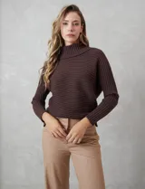 Buzo de tejido acanalado color blanco, con cuello alto y diseño de patrón en V en el frente. Presenta un corte holgado con mangas integradas sin costura de sisa.