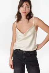 Blusa de satén color beige, sin mangas, con escote drapeado y tirantes finos.
