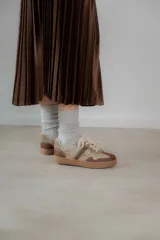 Championes urbanos de diseño acolchado, combinando tonos marrones, beige y detalles metalizados con textura. Cuentan con cordones al tono y suela de goma color caramelo.