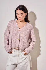 Cardigan de punto texturado en color rosa viejo, con escote en V, cierre frontal de botones y mangas largas con puños acanalados.