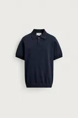 Polo de punto tejido en hilatura de algodón, color azul marino, de corte regular fit, con cuello solapa, cierre frontal de botonadura y manga corta con acabados en rib.
