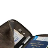 Portapasaporte de cuero genuino con acabado texturizado y cierre perimetral. Cuenta con tecnología de protección anticlonación, capacidad para dos pasaportes, seis tarjetas, efectivo y documentos de viaje.