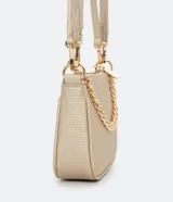 Bolso baguette dorado con correa de hombro y cadena decorativa.