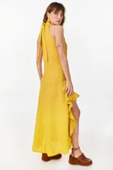 Vestido midi marrón de lino italiano, con cuello halter, sin mangas y diseño asimétrico con volados en el ruedo.
