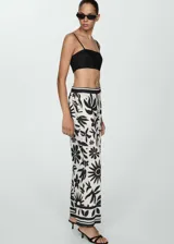 Pantalon de corte wideleg con cintura elastizada, confeccionado en tejido fluido con estampado floral en contraste. Presenta bolsillos laterales y diseño largo.