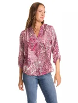 Blusa de gasa con estampado geométrico y paisley en tonos fucsia y blanco. Presenta cuello mao con escote en V, mangas tres cuartos con presilla y botón para regular el largo.