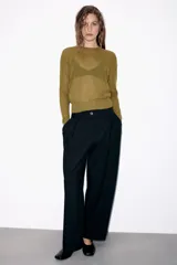 Jersey de punto fino con cuello redondo y manga larga con puños elásticos. Presenta un diseño minimalista con costuras visibles en los hombros.