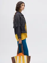 Campera de denim color marrón con cuello camisero, cierre frontal con botones y flecos en la parte superior de la espalda.