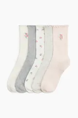 Pack de cinco pares de medias de punto acanalado en colores pastel y neutros, con detalle de ribete sobrehilado en el borde superior y bordados de flores pequeñas.