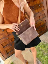 Cartera tipo bandolera de cuero, con solapa superior en textura de cocodrilo y cuerpo liso en tono marrón. Presenta detalles de costura decorativa en el borde de la solapa y correa larga ajustable.