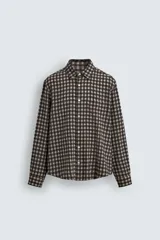 Camisa de corte relajado con estampado de cuadros, cuello solapa, manga larga con puños abotonados y bolsillo de plastrón en el pecho.