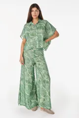Pantalón de lino italiano con diseño estampado a rayas verticales en tonos negro y beige, de tiro medio y corte ancho.