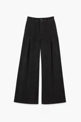 Pantalon de pana negra con corte wide leg, tiro alto y pinzas frontales. Cuenta con cierre de botón y cremallera, además de bolsillos laterales.