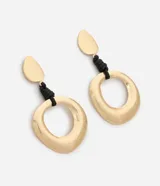 Maxi aros colgantes de metal dorado con diseño escultural y orgánico, con detalle de hilo encerado negro en la unión.