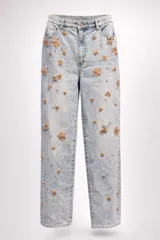 Jean de corte recto y tiro medio, confeccionado en denim de lavado claro. Presenta apliques decorativos de flores bordadas con lentejuelas y pequeñas cuentas metálicas distribuidas por toda la prenda. Cuenta con cierre de botón y cremallera, además de bolsillos funcionales.