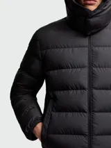 Campera puffer negra con capucha, cierre frontal con cremallera y logo de la marca en la manga izquierda.