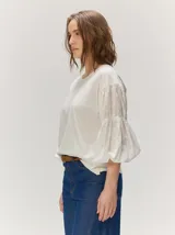 Remera blanca con cuerpo de algodón liso y mangas abullonadas semitransparentes con textura de lunares.
