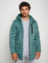 Parka larga gris con capucha, cierre frontal con cremallera y botones a presión, múltiples bolsillos y logo de Umbro en el pecho.