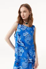 Vestido largo azul con estampado de estrellas de mar y flores. Tiene breteles finos regulables, cuello redondo y espalda descubierta.