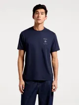 Camiseta blanca de algodón con cuello redondo y mangas cortas. Estampa rectangular con borde negro que contiene la frase "NATURAL ATMOSPHERE" en letras mayúsculas y una imagen de montañas y mar.