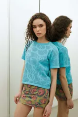 Remera de tejido de punto color celeste, de manga corta, con diseño calado en el frente.