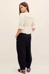 Pantalón babucha negro de lino, de corte holgado estilo barrel con pinzas en la cintura y bolsillos laterales.