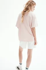 Remera rosa pálido de corte holgado, con cuello redondo y mangas cortas. Confeccionada en tejido de punto suave.