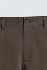 Pantalón chino de corte recto confeccionado en algodón. Presenta bolsillos frontales, un pequeño bolsillo cerillero y bolsillos traseros de vivo con botón. Cierre frontal con cremallera y botón.