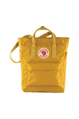 Bolso amarillo mostaza de la marca Fjällräven, modelo Kånken Totepack. Cuenta con doble asa corta superior, correa larga ajustable y logo circular reflectivo en el frente.