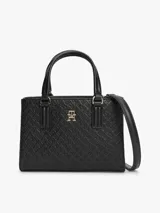 Cartera tote negra de poliuretano con acabado texturizado, motivo integral del monograma TH en bajo relieve, insignia metálica dorada en el frente, dos asas superiores y correa cruzada extraíble.
