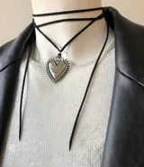 Gargantilla de tiento negro con dije de corazón calado de acero quirúrgico.