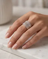 Anillo ancho de acero quirúrgico compuesto por múltiples bandas texturizadas con perforaciones circulares y detalles de brillo.