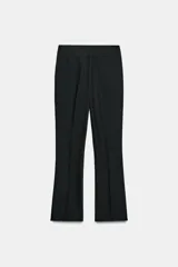 Pantalón de tiro medio con cintura elástica y corte mini flare, acabado en evasé. Cuenta con cierre lateral con cremallera oculta en la costura.