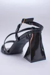 Sandalia negra de tacón con punta cuadrada y tiras finas cruzadas en el empeine.