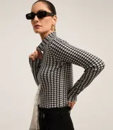 Suéter de cuello alto con estampado de pata de gallo en blanco y negro.