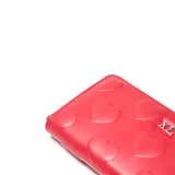 Billetera XL de formato rectangular en color rojo, con diseño de corazones en relieve y logo metálico plateado en la parte frontal. Cuenta con cierre perimetral.