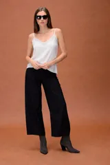 Musculosa estilo lencero de satén color blanco, con escote en V decorado con encaje y breteles finos ajustables.