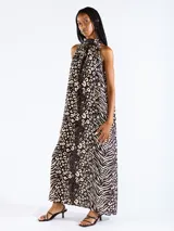 Vestido largo halter con estampado de animal print, en color negro, confeccionado en tejido liviano con hombros descubiertos.